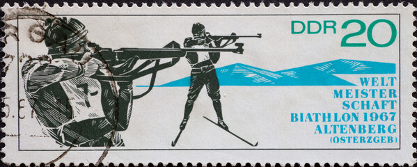 GERMANY, DDR - CIRCA 1967 : a postage stamp from Germany, GDR showing two athletes in standing shooting. Biathlon World Championships, Altenberg