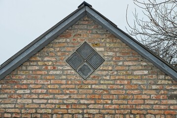 Sticker - old brown brick loft with a small one gray window against a sky