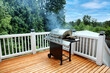 © tab62 - Barbecue cooking with lid closed and visual smoke coming out on outdoor home patio