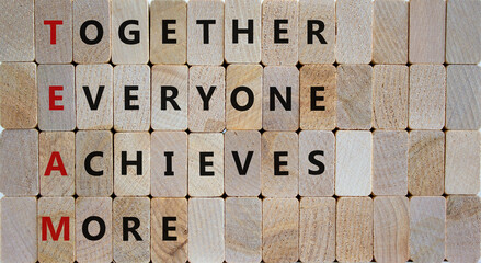 Wall Mural - TEAM, together everyone achieves more symbol. Wooden cubes with words 'TEAM, together everyone achieves more'. Beautiful wooden background, copy space. Business, motivational and TEAM concept.