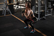 © Ihor - Sportswoman squatting with resistance band at the gym, copy space