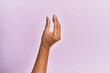 © Krakenimages.com - Arm and hand of caucasian young man over pink isolated background picking and taking invisible thing, holding object with fingers showing space