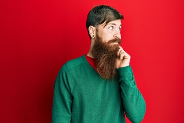 Canvas Print - Redhead man with long beard wearing casual clothes thinking concentrated about doubt with finger on chin and looking up wondering