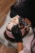 © Vita - eyebrow microblading. A master in black gloves draws the pigment for the procedure onto the handpiece with a shading needle.