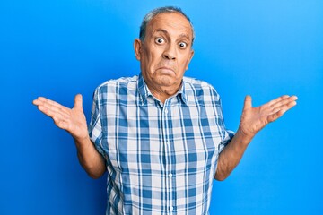 Canvas Print - Senior hispanic man wearing casual clothes clueless and confused with open arms, no idea and doubtful face.