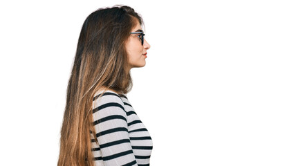 Wall Mural - Young beautiful teen girl wearing casual clothes and glasses looking to side, relax profile pose with natural face with confident smile.