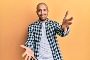 Poster - Hispanic adult man wearing casual clothes looking at the camera smiling with open arms for hug. cheerful expression embracing happiness.