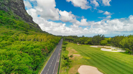 Wall Mural - Golf course along a beautiful island coastline, drone point of view