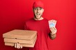 © Krakenimages.com - Young caucasian man holding delivery box and swiss franc banknotes celebrating crazy and amazed for success with open eyes screaming excited.