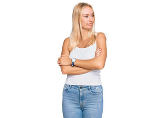 Poster - Young blonde girl wearing casual style with sleeveless shirt looking to the side with arms crossed convinced and confident