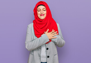 Sticker - Beautiful hispanic woman wearing traditional islamic hijab scarf smiling with hands on chest with closed eyes and grateful gesture on face. health concept.