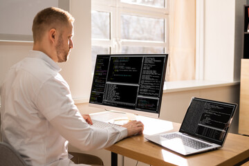Computer Programmer Writing Program Code On Computer