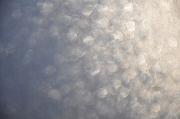 Silver blurred bokeh background, gray, white circles, beige, defocusing, holiday, glitter, glow, light effect, magic