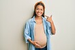 © Krakenimages.com - Beautiful hispanic woman expecting a baby, touching pregnant belly smiling cheerful showing and pointing with fingers teeth and mouth. dental health concept.