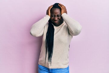 Poster - Young black woman with braids wearing casual winter sweater suffering from headache desperate and stressed because pain and migraine. hands on head.