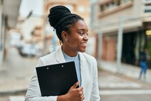 Young African American Businesswoman Smiling Happy Holding Clipboard At The City.