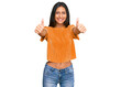 © Krakenimages.com - Young brunette arab woman wearing casual clothes approving doing positive gesture with hand, thumbs up smiling and happy for success. winner gesture.