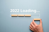 Fototapeta  - Hand folds from wooden blocks concept of loading new year 2022
