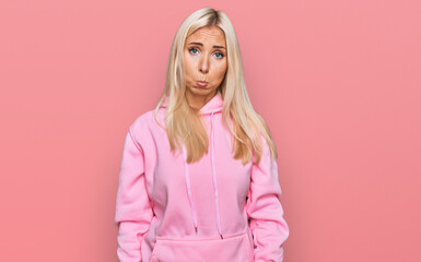 Wall Mural - Young blonde woman wearing casual sweatshirt depressed and worry for distress, crying angry and afraid. sad expression.