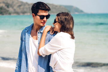 Vacation romantic lovers young happy couple hug and standing on sand at sea having fun and relaxing together on tropical beach.Summer vacations