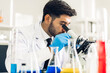 © Art_Photo - Professional scientist man research and working doing a chemical experiment while making analyzing and mixing liquid in test tube.Young science man looking sample chemical on glass at laboratory