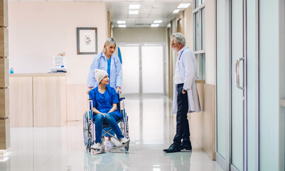 Wall Mural - Professional medical doctor team with stethoscope in uniform discussing with patient woman with cancer cover head with headscarf of chemotherapy cancer in hospital.health care concept