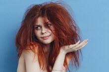 Red-haired Woman With Tousled Hair On Blue Background Gesturing With Hands Cropped View