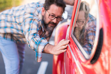 Adult Bearded Hipster Man Check The Polish Of His Beautiful Car Outdoor - People And Automobile Transportation Love And Care Concept - Driver Look The Exterior Of His Auto