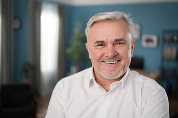 Happy mature gray-haired 60s man smiling face white healthy teeth dental smile. Relaxed old retired single grandfather posing alone at home look at camera, close up portrait.