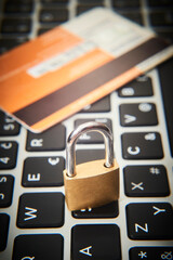 Padlock and credit cards on  computer keyboard. E-commerce data, eshopping and ebanking protection, internet and finance security concept. Selective focus to padlock
