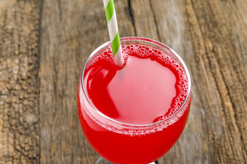 red juice or berry compote with splashes in glass isolated on wooden background