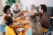 © NDABCREATIVITY - Multiethnic diverse extended family dining and toasting together