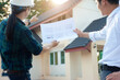 © Wasan - Architects and contractors hold design plans and discuss home renovation. The inspector is inspecting the construction project.
