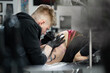 © Studio Peace - Professional tattoo artist makes a tattoo on a young girl's leg