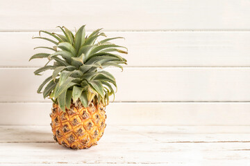 Fresh pineapple on white wooden background with copy space.