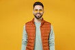 © ViDi Studio - Young smiling happy friendly cheerful fun caucasian man 20s years old wearing orange vest mint sweatshirt glasses looking camera isolated on yellow background studio portrait People lifestyle concept.
