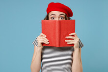 Young Smart Student Woman 20s With Short Hairdo Wear French Beret Red Hat Striped T-shirt Hiding Cover Face Mouth With Diary Read Book Novel Isolated On Pastel Blue Color Background Studio Portrait