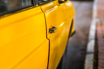 Side door details of an antique yellow car