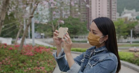 Poster - Woman wear face mask and use of mobile phone at park