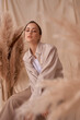 © Dmitry Tsvetkov - Fall fashion portrait. Brunette girl with pony tail and natural makeup. Elegant woman posing between ears of rye at textile background. Stylish female model in brown skirt anf beige jacket