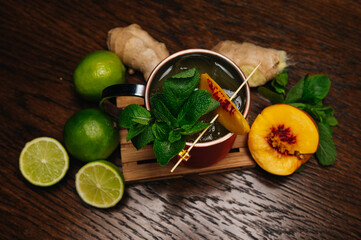 Cocktail in iron mug with peach, lime, mint and ginger 