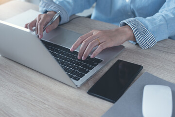 Sticker - Woman hands typing on laptop computer surfing the internet and online working in office