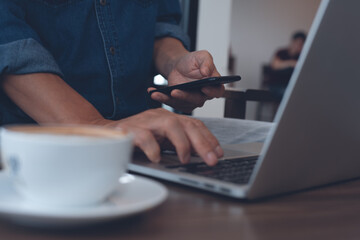 Wall Mural - Casual business man, freelancer online working on laptop computer on table at coffee shop