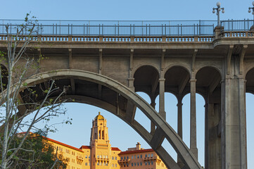 This image shows a juxtaposition of the Colorado Street Bridge and the Richard Chanbers Courthouse building, two landmark in the City of Pasadena, Los Angeles County.