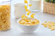 © k_e_n - Traditional breakfast with cornflakes and milk. Falling corn flakes.