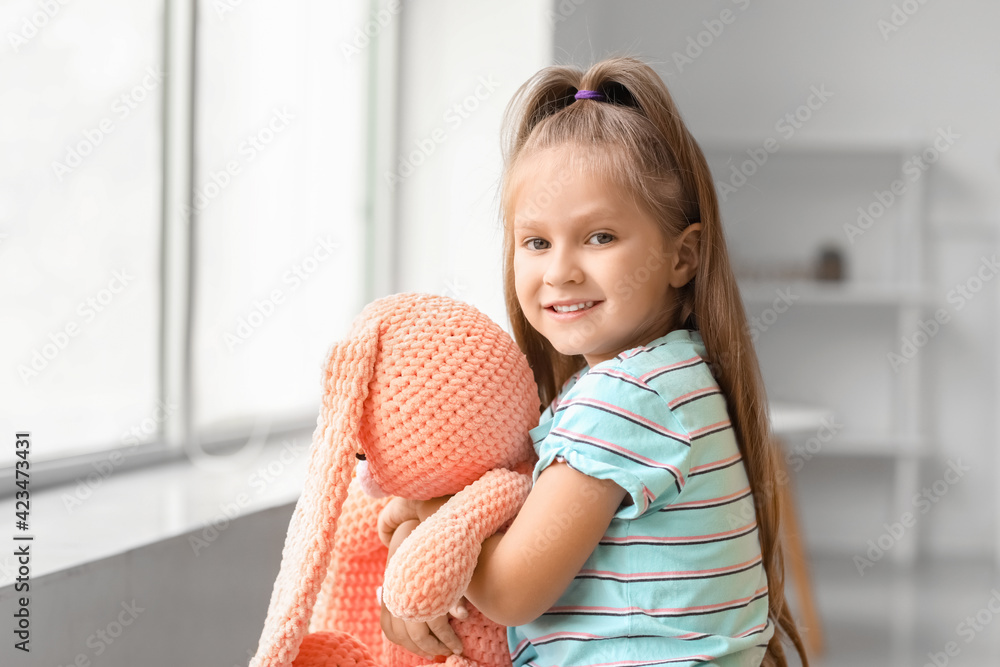 Cute little girl with toy at home