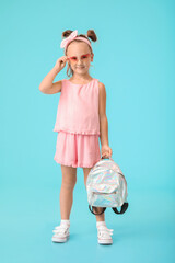 Poster - Cute little girl with backpack on color background