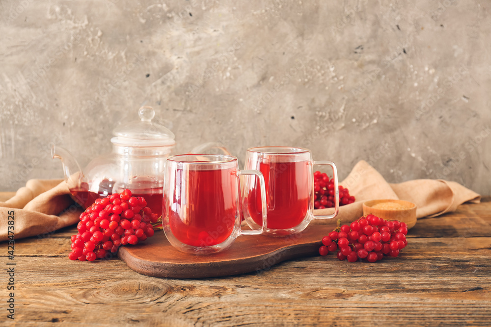 Cups of healthy viburnum tea on table