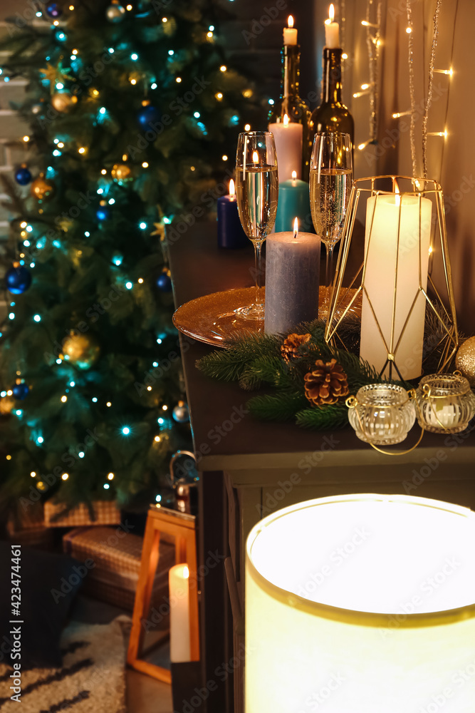 Candles and Christmas decor on mantelpiece in room