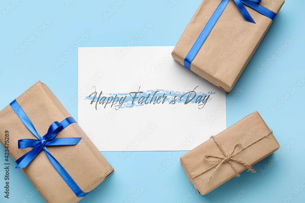 Gift boxes and greeting card for Father's Day celebration on color background
